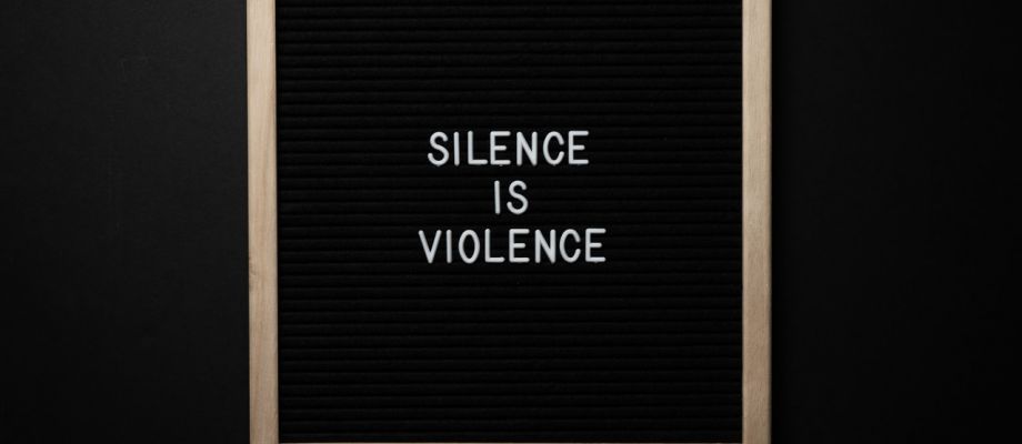 Tafel mit der Aufschrift "Silence Is Violence"